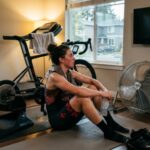 Cyclist sitting in front of a running floor fan during a post workout cooling routine after an intense indoor cycling session