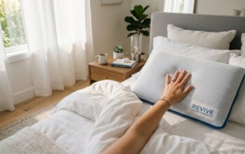 Hands feeling a cool-to-the-touch memory foam pillow on a neatly made bed.